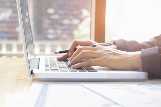 Business woman's hands typing on laptop keyboard