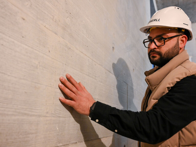 Eberli Mitarbeiter Junior-Bauleiter Armin Faragollah an Sichtbetonwand
